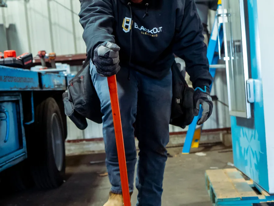 A Blackout Electric electrician bending conduit in the shop